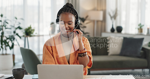 Image of Black woman, headset in home office with laptop and phone call, remote work and crm in apartment. Virtual assistant at desk with computer, typing and conversation for advice, online chat and support