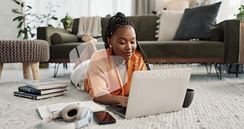 Image of Laptop, education and a student black woman on the floor of a living room to study for a test or exam. Computer, smile and a happy young person learning with an online course for upskill development