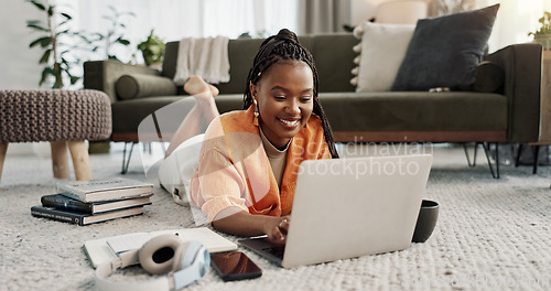 Image of Laptop, smile and woman typing on the floor in the living room of modern apartment for research. Technology, happy and young African female university student studying on a computer in lounge at home