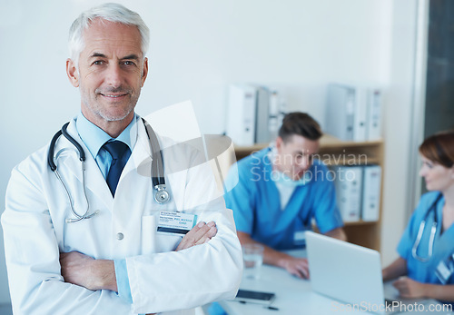 Image of Smile, crossed arms and portrait of doctor in meeting with nurses for medical research in hospital. Happy, confident and senior male surgeon in clinic office with healthcare workers for discussion.