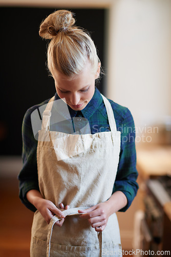 Image of Chef, woman and tie apron in kitchen, restaurant or catering service at hotel for gastronomy. Uniform, cooking and person with knot on clothes, culinary or preparation of professional waitress at job