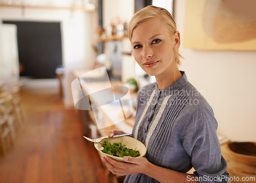 Image of Woman, portrait and salad bowl in kitchen or health nutrition for wellbeing, ingredients or fibre. Female person, face and wellness or vegan meal in apartment for diet leafy greens, food or cooking