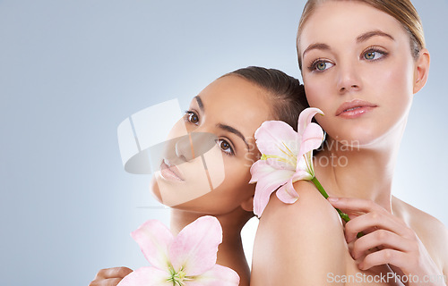 Image of Woman, skincare and flowers for natural beauty, makeup or cosmetics in relax on a blue studio background. Young female, people or models in calm satisfaction for spa or facial treatment on mockup