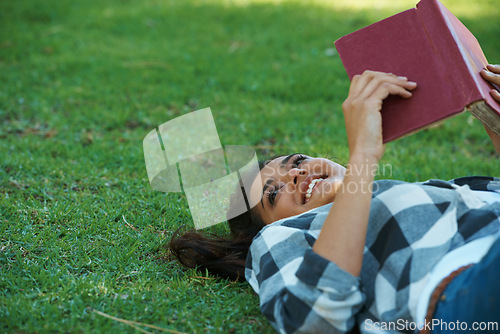 Image of Happy woman, student and lying with book on green grass for literature, studying or story in nature. Female person, bookworm or young adult with smile and notebook for reading or education at park