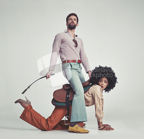 Image of Vintage, man and woman or riding crop in studio with piggyback, portrait and funny face for retro style. Friends, people and 70s outfit with hipster clothes or comic expression with white background