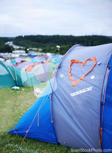 Image of Camping, festival and heart on tent at evening outdoor for event, party or celebration in nature. Field, forest or grass with shelter from weather on sky at campsite for adventure or getaway