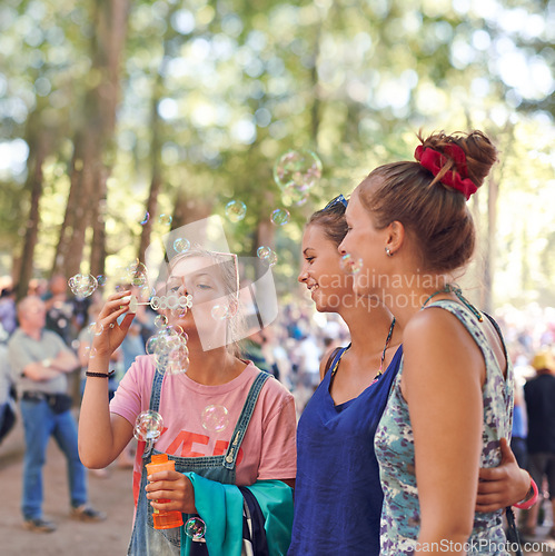 Image of Festival, woman and friends blowing bubbles outdoor at event or party for celebration in summer. Smile, event and happy young people in nature or forest for concert, entertainment or performance