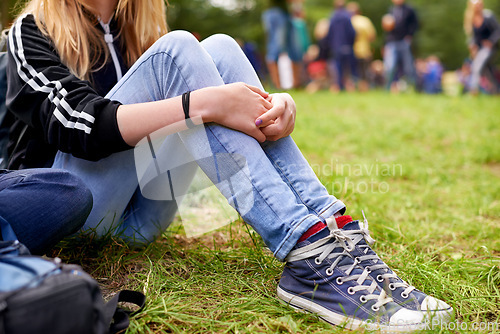 Image of Legs, shoes and person on grass closeup outdoor at event, festival or social gathering in green nature. Party, ground or field with casual woman sitting in forest, park or woods for entertainment