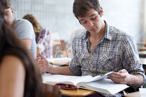 Image of College, books and man in classroom reading for development in learning, opportunity and future. Education, knowledge and growth for ambitious university student in lecture, studying for exam or test