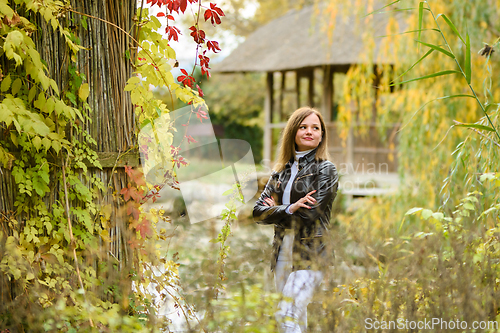 Image of A young beautiful girl walks in the forest near a pond