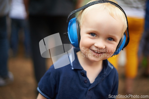 Image of Portrait, child and noise cancelling headphones at outdoor event with smile, fun and music. Protection, happiness and boy toddler at festival, concert or live performance with soundproof headset.