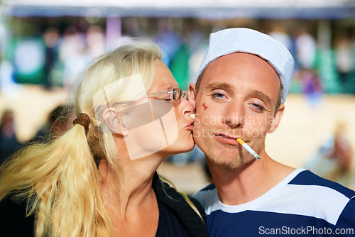 Image of Couple, music festival and happiness with kissing, portrait or bonding together with weekend break. Face, people or friends with joy or concert with a party or outdoor with fun or costume with summer