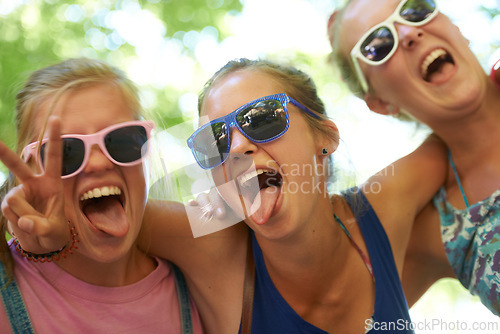 Image of Portrait, music festival and women with sunglasses, funny and silly with happiness and bonding together. Funky eyewear, goofy or outdoor with friends or peace sign with embrace, excited or summer fun