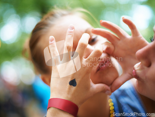 Image of Hands, lesbian couple and women with heart outdoor, bonding and fun at music festival. Closeup, sign and love of gay girls together for celebration with tattoo for care in nature on valentines day
