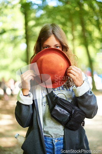 Image of Portrait, hat and woman at music festival, outdoor and peeking at event in summer. Face, fashion and girl hide behind fedora for style, shy and casual young person alone at party in France in nature