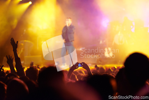 Image of Music festival, audience and hands in crowd with band for concert, night club and cheering with light. Disco, party and people with signs, gesture and performance at rock event with entertainment