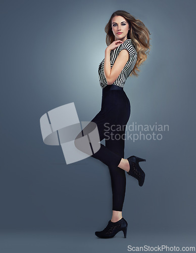 Image of Fashion, beauty and model with makeup and heels, glamour and style with hair shine isolated on grey background. Cosmetics, fashionable clothes and portrait, cosmetology and designer outfit in studio