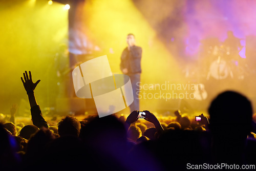 Image of Concert, audience and hands in crowd with band for music festival, night club and cheering with light. Disco, artist and people with sign, gesture and performance at rock event with entertainment