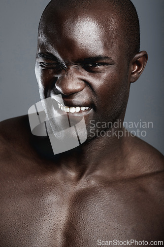 Image of Skincare, health and portrait of black man in studio with wink and flirting facial expression. Spa, wellness and young African male person with clean face dermatology treatment by gray background.