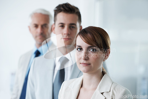 Image of Portrait of three corporate business people , standing in a row and in broad room. Smiling friendly group of three business partners of different age private company staff posing for office