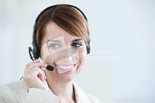 Image of Woman, callcenter and phone call with headset and mic, CRM or contact us with smile for communication. Telecom, customer service or telemarketing with agent for tech support or help desk at office