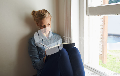 Image of Woman, window and writing ideas in notebook, planning and brainstorming or reminder for schedule at home. Female person, information and journal for inspiration, author and notes in diary for project