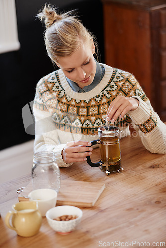 Image of Woman, happy and herbal tea for calm in home and warm beverage of herbs mixture for health. Kitchen, person and detox with dry leaves in plunger and chamomile drink to relax in apartment in above