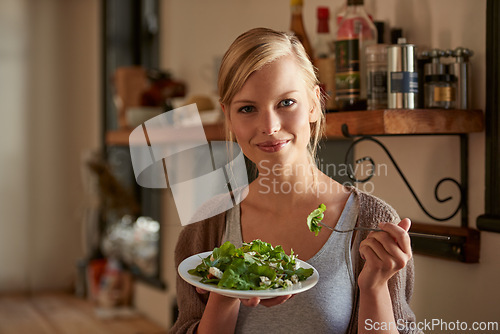 Image of Portrait, woman and eating salad in kitchen at home, nutrition and fresh leafy greens for healthy diet. Vegetables, bowl and face of hungry person with food, fork and organic vegan meal for wellness