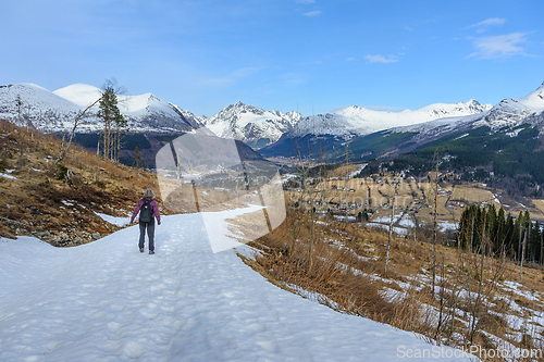 Image of Lone hiker trekking on a snow-covered mountain path during winte
