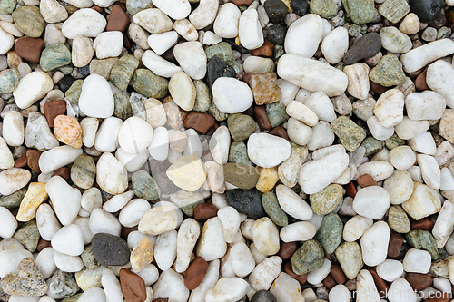 Image of Assortment of smooth multi-colored pebbles covering the ground i