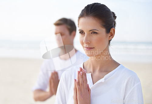 Image of Meditation, yoga and couple on beach in morning for fitness, exercise and mindfulness. Nature, love and man and woman by ocean with prayer hands for calm, wellness and healthy body outdoors together