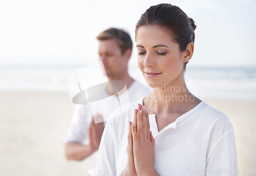 Image of Praying hands, couple and meditation on beach for zen and wellness with holistic healing outdoor for calm and yoga. Ocean, people and mindfulness together for bonding, peace and spiritual in nature