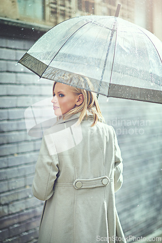 Image of Woman, umbrella and walking with rain in city, thinking or ideas with cover, weather and memory in winter. Person, outdoor and road with travel, journey or commute with water on sidewalk in Cape Town