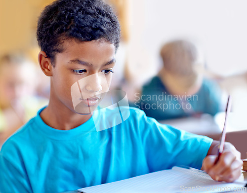 Image of Student, boy and writing notes for knowledge in classroom, book and problem solving at school. Male person, child and study information for exam prep in notebook, solution and journal for assessment