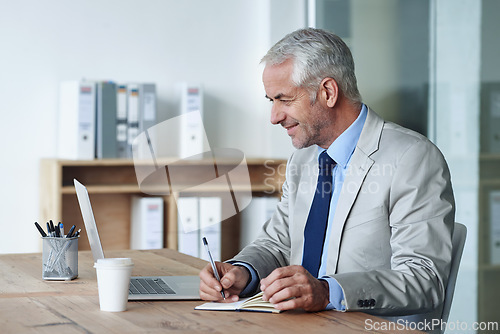 Image of Man, boss and notes while working on laptop, coffee and office for stakeholder budget account. Senior, manager and indoors for company, book and writing in diary at desk preparing for meeting