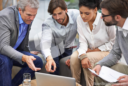 Image of Business people, laptop and meeting with team for planning, strategy or brainstorming at office. Group of employees on computer with documents for discussion, research and development at workplace