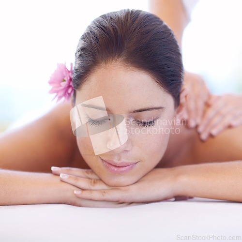 Image of Relax, massage and face of woman at spa with smile, flower for health with luxury holistic treatment. Self care, peace and girl on table with masseuse for body therapy, wellness and hotel service