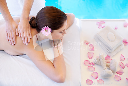 Image of Flowers, massage and woman at spa pool for health, wellness and luxury holistic treatment. Self care, peace and girl on table with masseuse for body therapy, relax and calm hotel service with petals