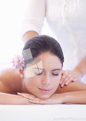 Image of Relax, massage and woman at wellness spa with flower for health, rest and luxury holistic treatment. Self care, peace and girl on table with masseuse for body therapy, balance and calm hotel service