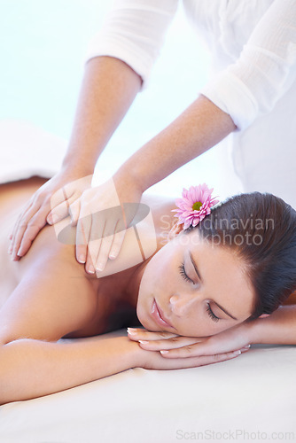 Image of Calm, massage and woman at wellness spa with flower for health, relax and luxury holistic treatment. Self care, peace and girl on table with masseuse for body therapy, balance and hotel service.