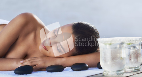 Image of Sleeping, hot stone or woman in spa with beauty or flower for wellness, treatment or hospitality. Relax, resort or healing therapy for happy person, client or masseuse in hotel on holiday vacation