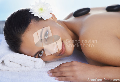 Image of Sleeping, hot stone or woman in spa with smile or flower for wellness, treatment or hospitality. Relax, resort or healing therapy for happy person, client or masseuse in hotel on holiday vacation