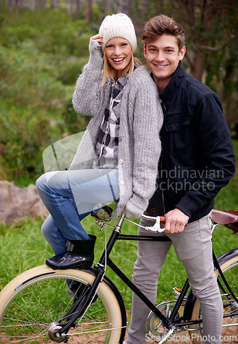 Image of Couple, portrait and park with retro bicycle on holiday, adventure and date with sustainable transport. Man, woman and vintage bike with smile for holiday with journey in woods, path or environment