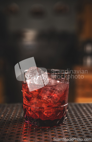 Image of Elegant glass of red cocktail on bar counter