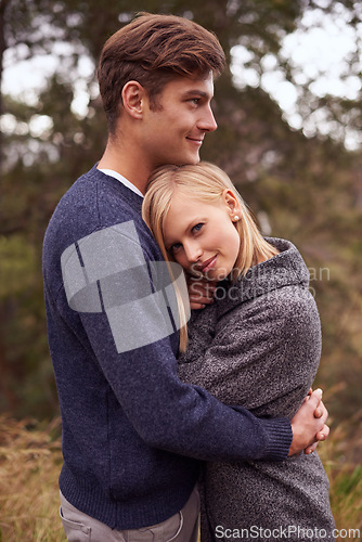 Image of Couple, portrait and smile with hug outdoor in countryside for holiday, vacation and anniversary getaway in forest. Love, man and woman with face, happy and embrace in woods for relationship and care