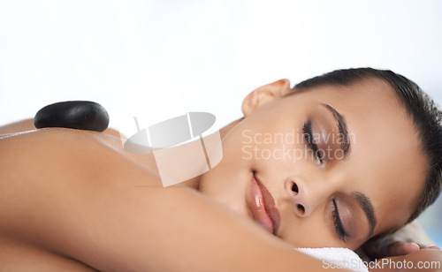 Image of Relax, hot stone and woman with massage at spa for wellness, health and back treatment. Self care, cosmetic and young female person sleeping for warm stone back therapy at natural beauty salon.