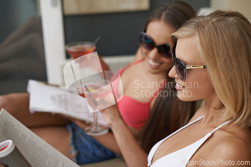 Image of Friends, women and travel with alcohol at hotel, bonding and drinking wine on tropical vacation. People, reading news and magazine for gossip on summer holiday, weekend trip and cozy at resort