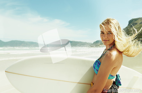 Image of Portrait, wind and woman on beach with surfboard in summer for sports, travel or vacation on coast. Face, fitness and happy young surfer person on sand by sea or ocean for surfing hobby or leisure