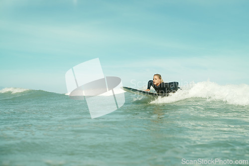 Image of Summer, sports and woman on surfboard in sea with space for outdoor travel, vacation or holiday. Ocean, wave and splash with young surfer person outdoor on blue sky for fitness, exercise or training