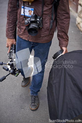 Image of Lighting, equipment and photographer in outdoor for photoshoot with camera lens and gear. Cameraman, walking and photography tools for press, project and person travel on street with reflector tech